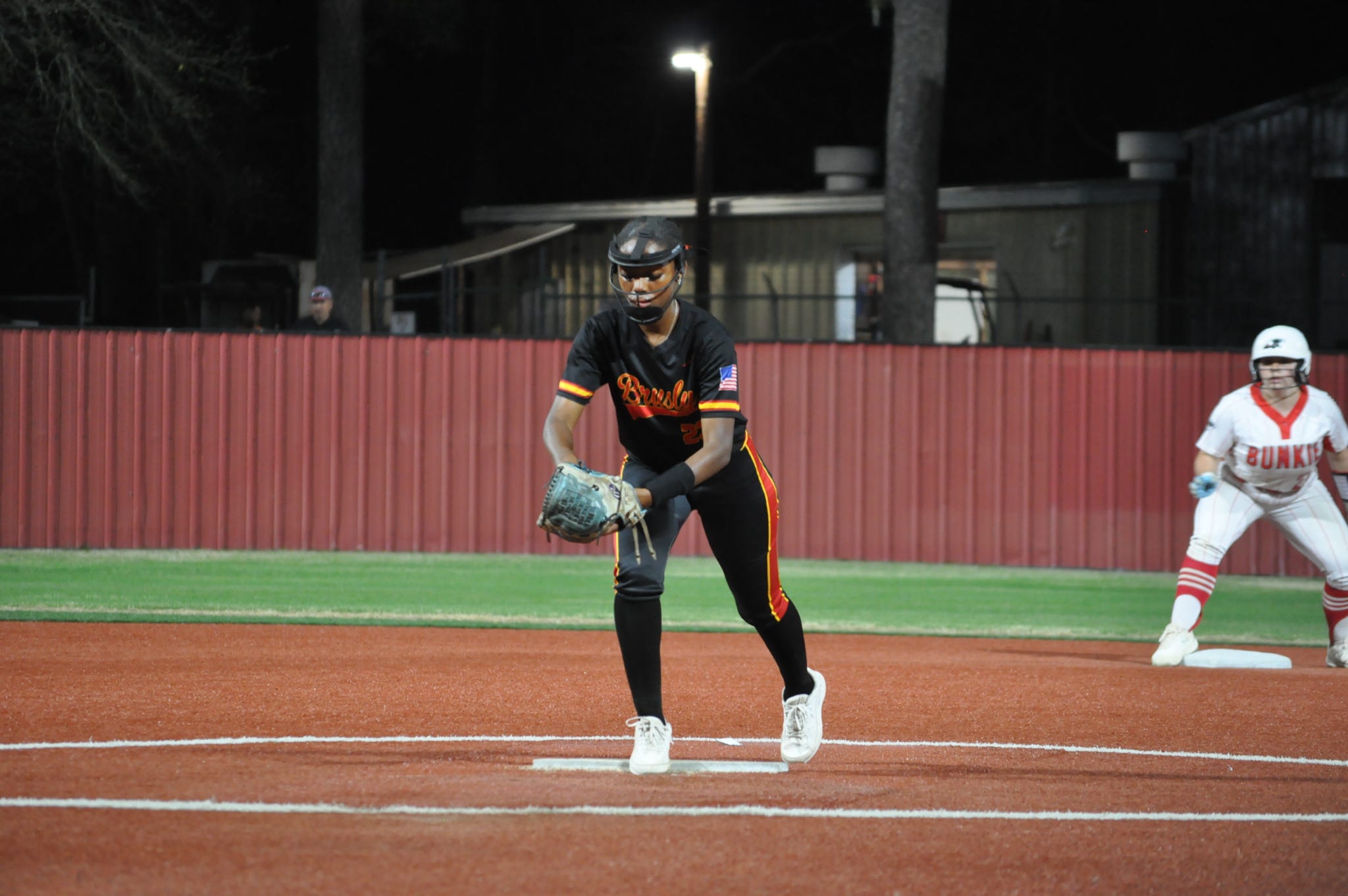 Skye Hebert set in a ready fielding stance under the lights