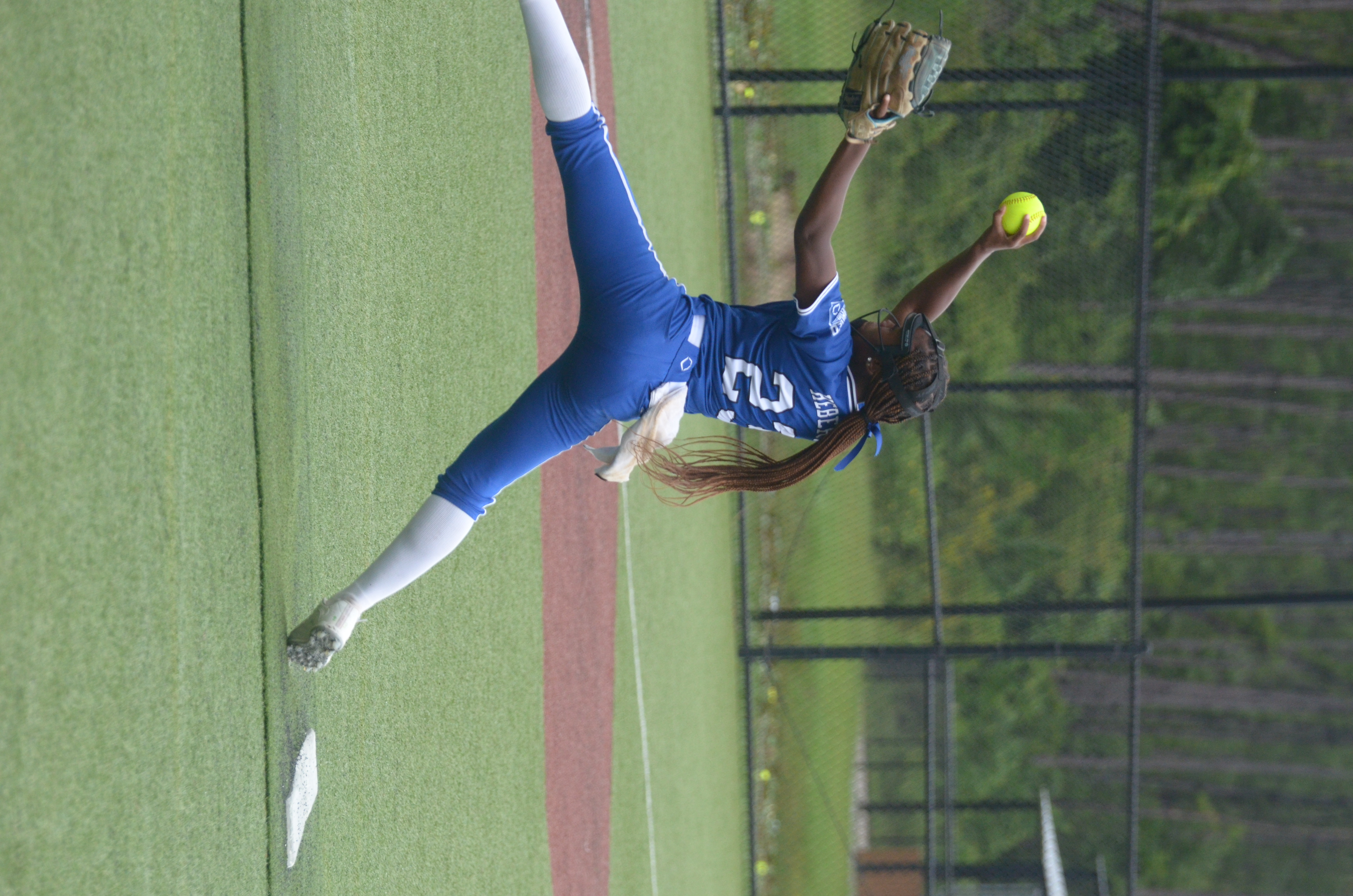 Skye Hebert mid-windup on the mound in her LA Lady Dukes blue uniform